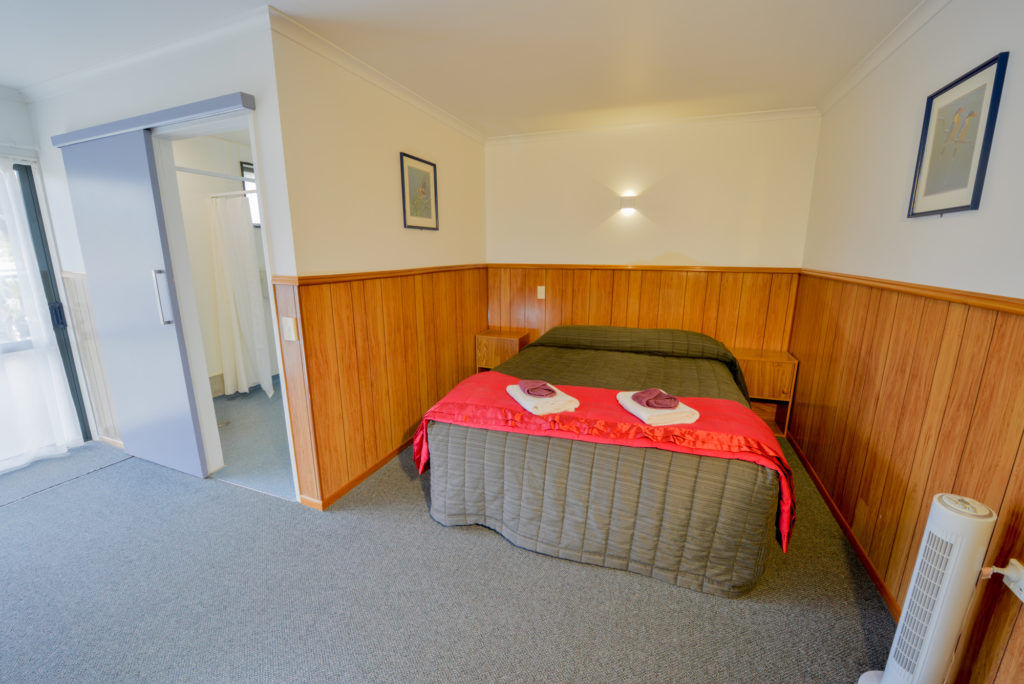 Queen size bed in motel wilderness haast new zealand